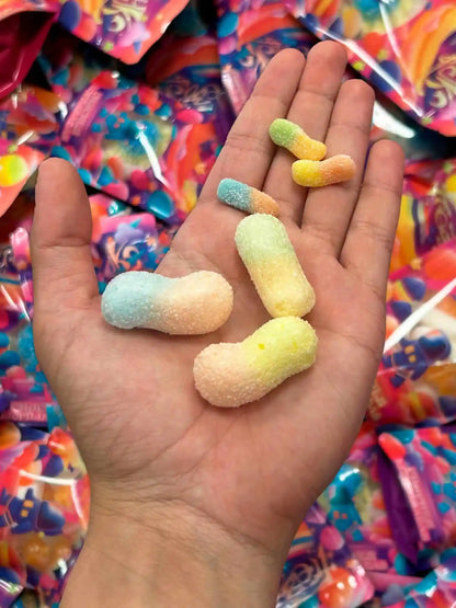 Minigusanos ácidos liofilizados de Frezzyks en una mano junto a su tamaño original