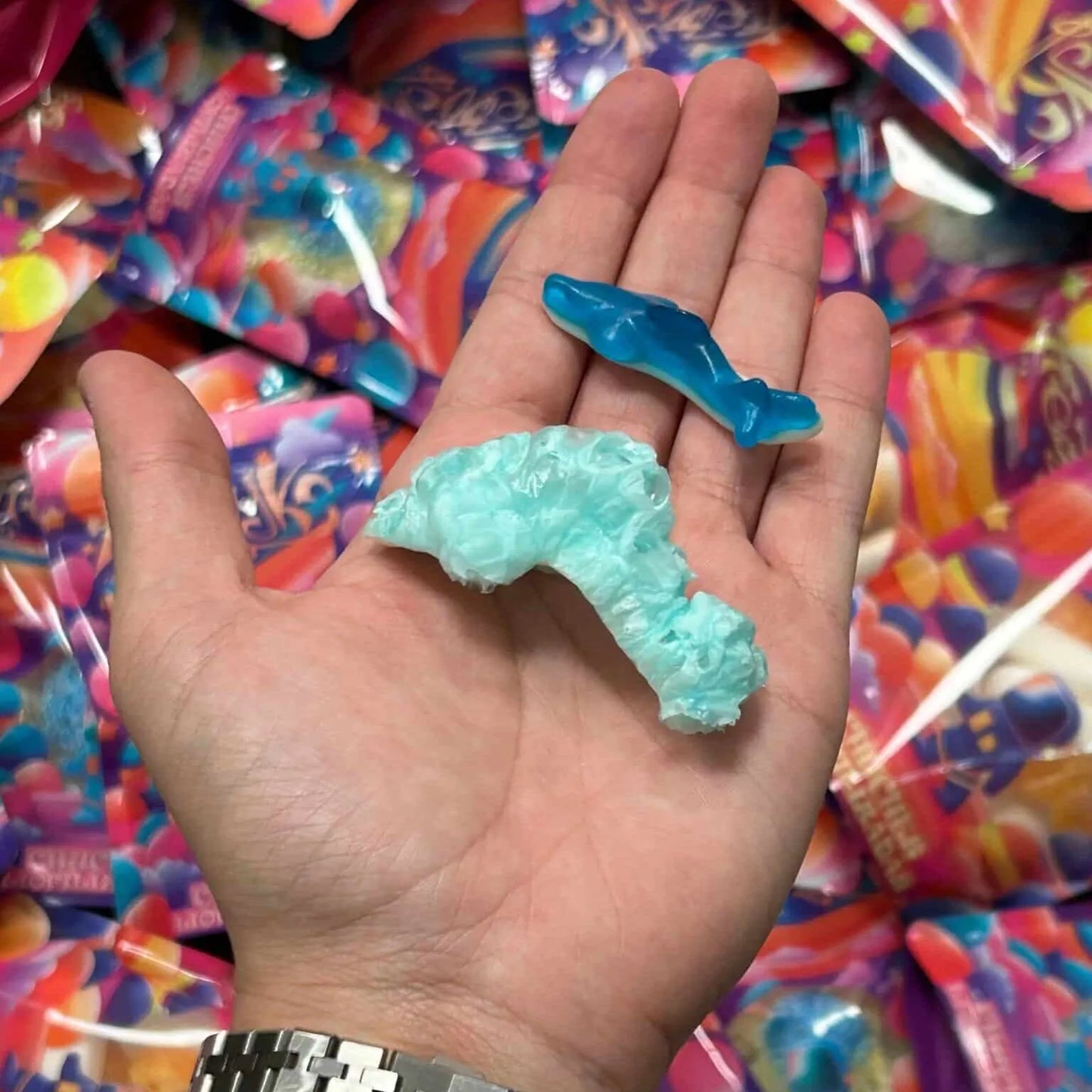 Tiburones liofilizados de Frezzyks en una mano junto a su tamaño original